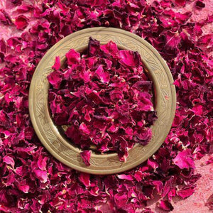 Edible magenta dried rose petals on a decorative plate for culinary or wellness use