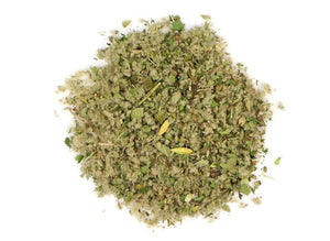 Loose herbal smoking blend mix with green and brown plant fragments on white background