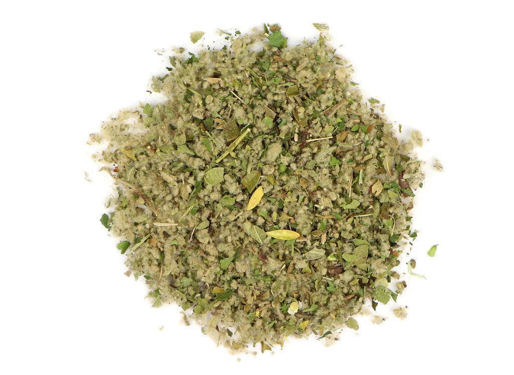 Loose herbal smoking blend mix with green and brown plant fragments on white background