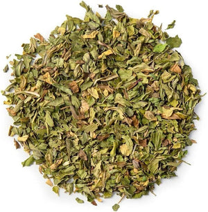 Loose dried peppermint leaves in a pile, herbal wellness product on white background