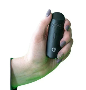 Hand holding a compact black dry herb vaporizer for discreet portable use