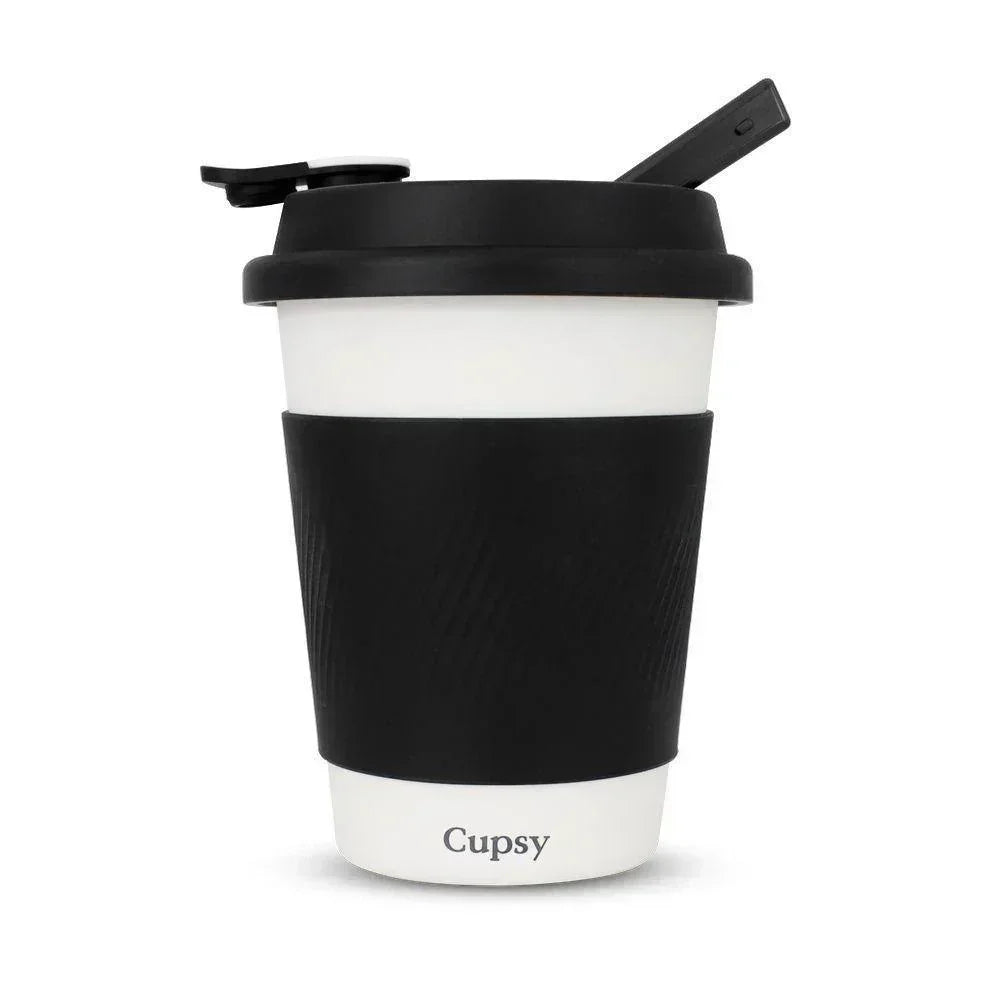 Discreet black and white travel cup with lid and sleeve, labeled Cupsy, for wellness use