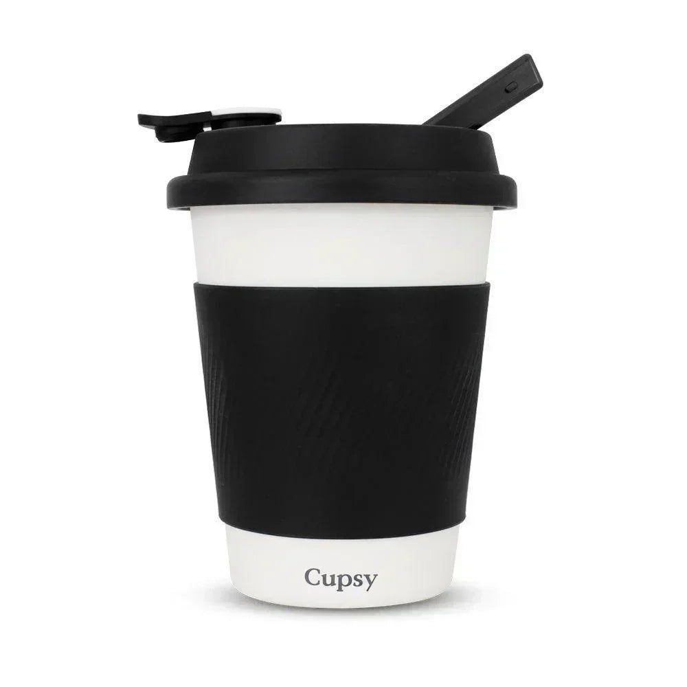 Discreet black and white travel cup with lid and sleeve, labeled Cupsy, for wellness use