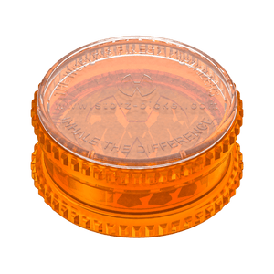 Transparent orange herb grinder with textured edges for herb preparation