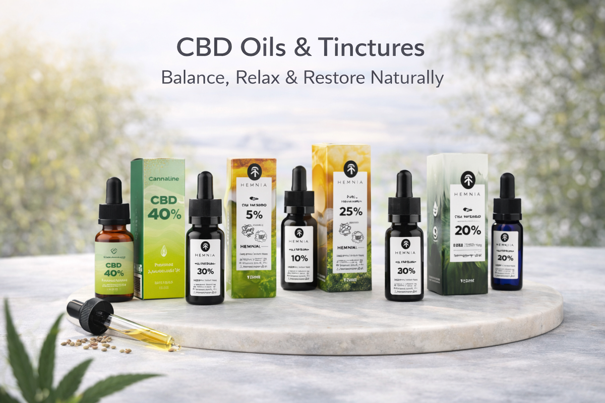 Selection of CBD oil and tincture bottles with droppers, outdoor nature backdrop.
