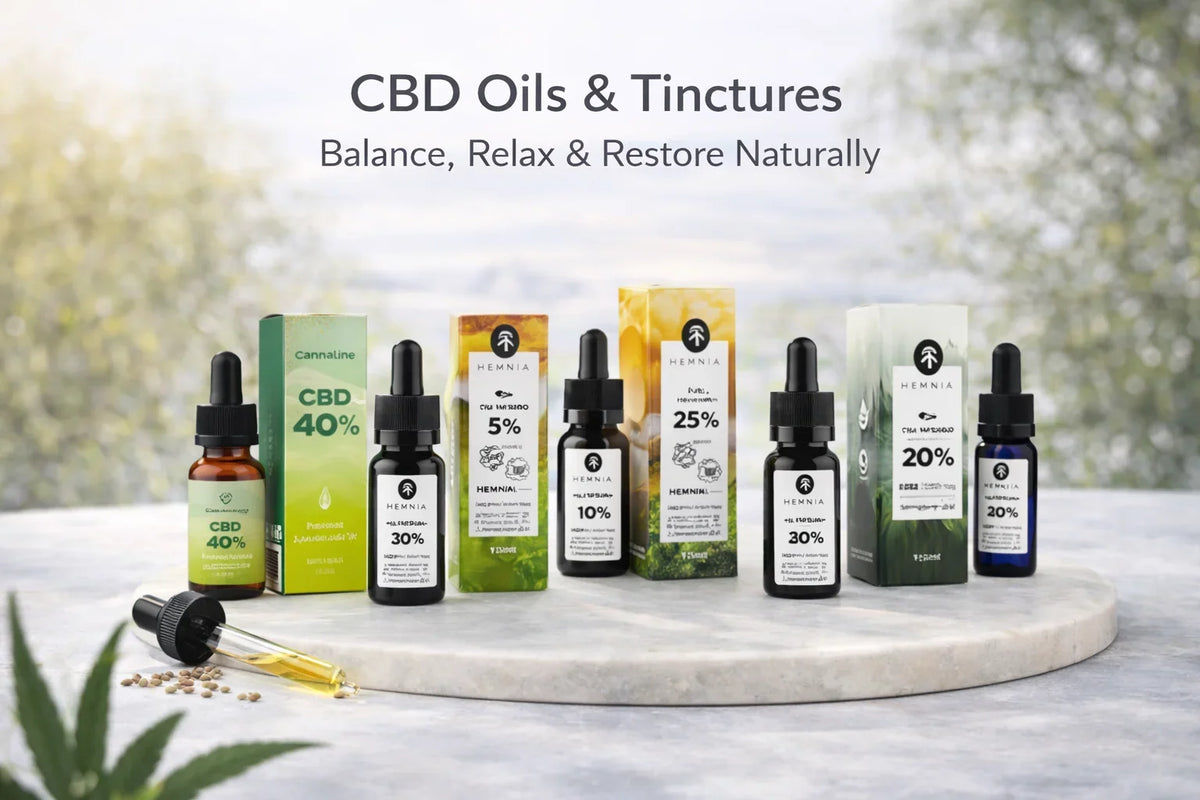 Selection of CBD oil and tincture bottles with droppers, outdoor nature backdrop.